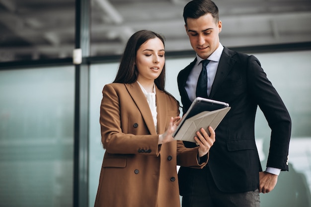 Hombres y mujeres de negocios trabajando en tableta en la oficina