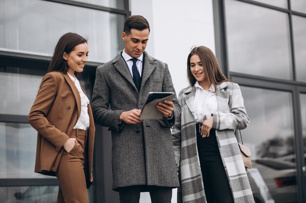 Hombres y mujeres de negocios trabajando en tableta en la oficina