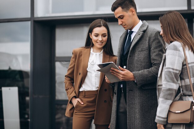 Hombres y mujeres de negocios trabajando en tableta en la oficina