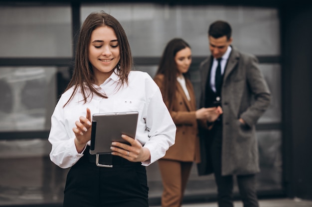 Hombres y mujeres de negocios trabajando en tableta en la oficina