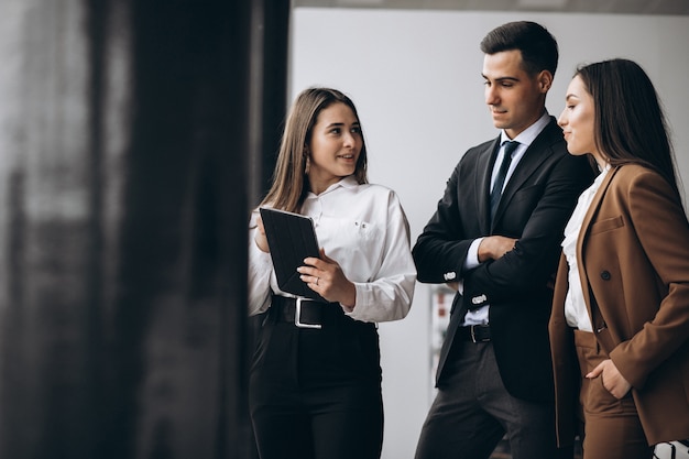 Hombres y mujeres de negocios trabajando en tableta en la oficina