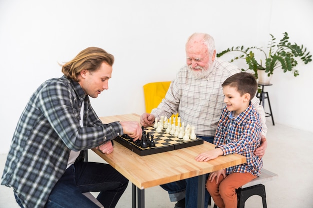 Hombres multigeneracionales jugando al ajedrez.