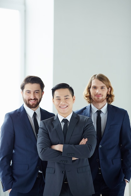 Hombres de negocios alegres junto a la ventana