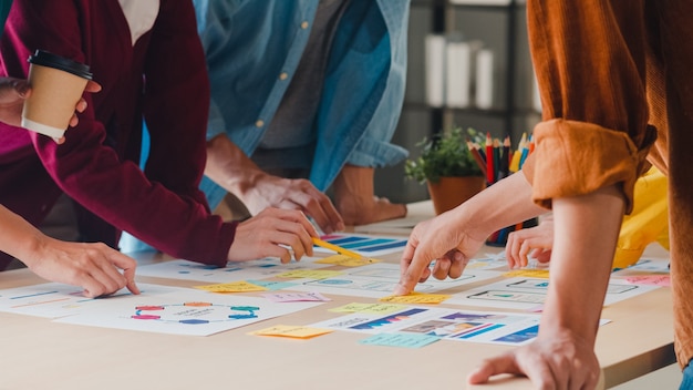 Foto gratuita hombres de negocios asiáticos y mujeres de negocios que se reúnen para intercambiar ideas sobre la aplicación de planificación de diseño web creativo y desarrollar el diseño de la plantilla para proyectos de teléfonos móviles que trabajan juntos en una oficina pequeña