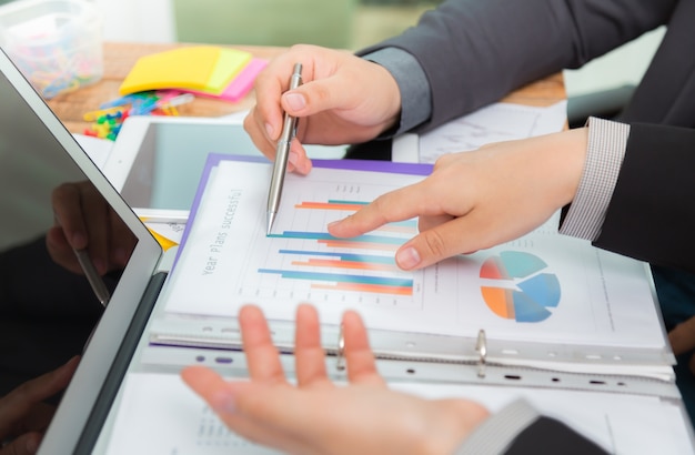 Hombres de negocios comparando resultados de una gráfica en una oficina