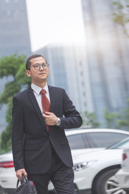 Los hombres de negocios llevar ordenadores portátiles en el estacionamiento