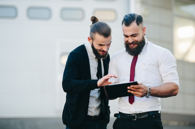 Foto gratuita hombres de negocios mirando una tableta