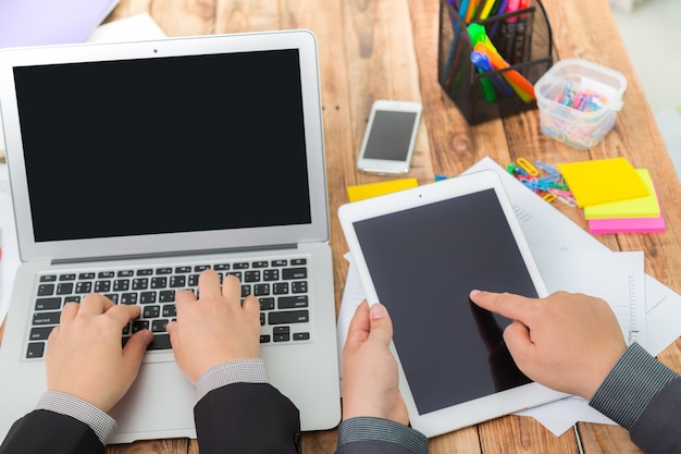 Hombres de negocios con un portátil y una tablet visto desde arriba y teléfono inteligente