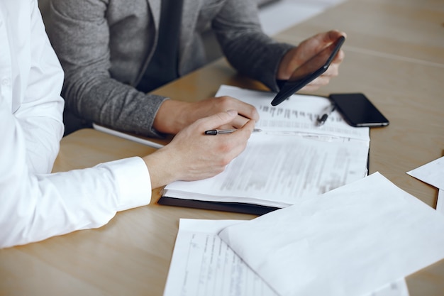 Hombres de negocios sentados en el escritorio de los abogados. Personas que firman documentos importantes.