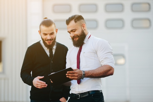 Foto gratuita hombres de negocios sonrientes con una tableta