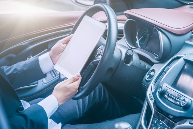 Los hombres de negocios trabajan con las computadoras tablet en sus coches