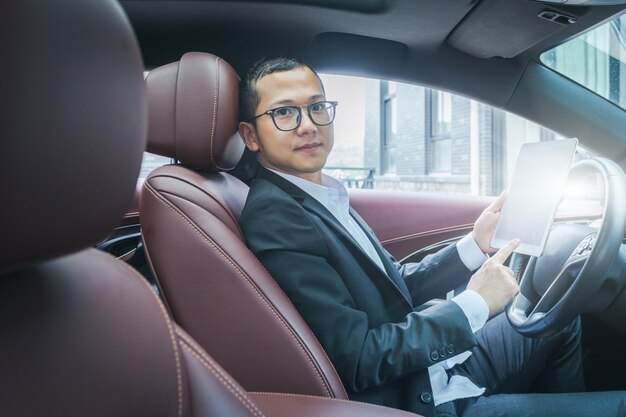 Los hombres de negocios trabajan con las computadoras tablet en sus coches