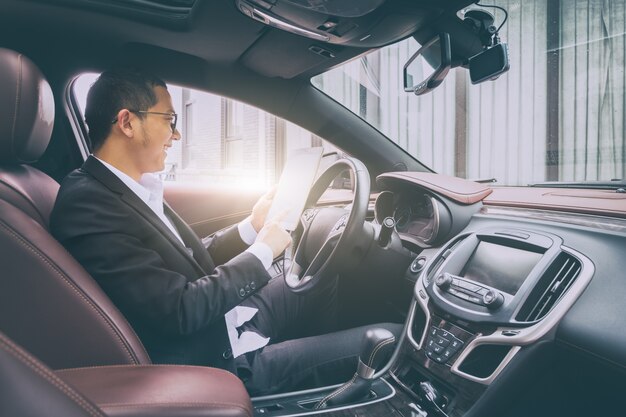 Los hombres de negocios trabajan con las computadoras tablet en sus coches