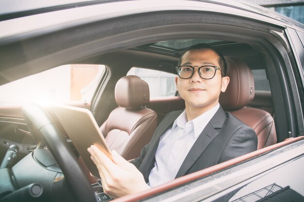 Los hombres de negocios trabajan con las computadoras tablet en sus coches