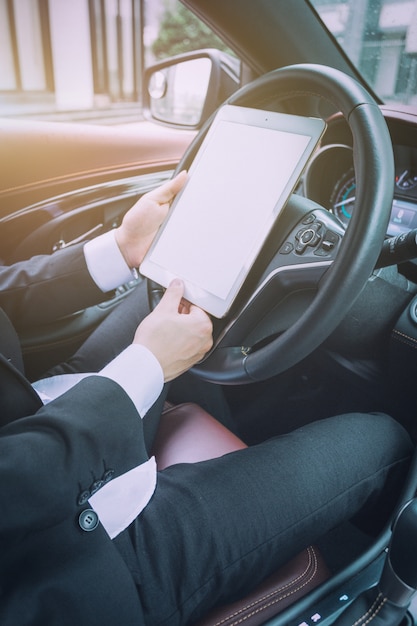 Los hombres de negocios trabajan con las computadoras tablet en sus coches