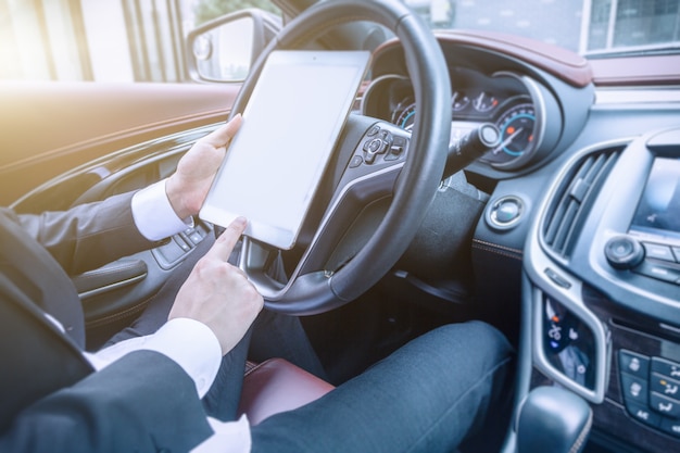 Los hombres de negocios trabajan con las computadoras tablet en sus coches