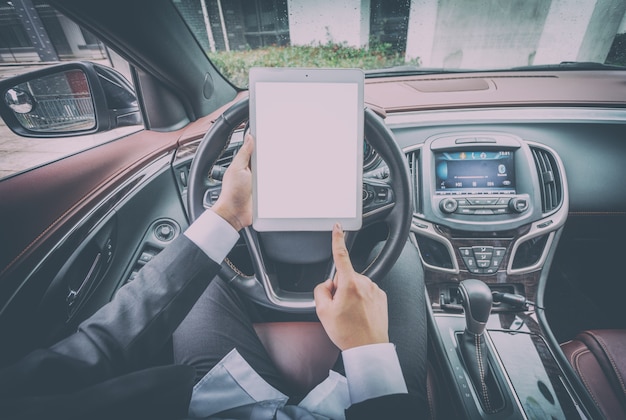 Los hombres de negocios trabajan con las computadoras tablet en sus coches