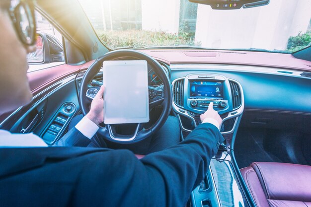 Los hombres de negocios trabajan con las computadoras tablet en sus coches