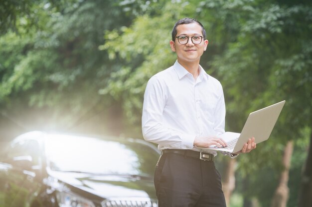 Los hombres de negocios trabajan con ordenadores portátiles en el lado del coche