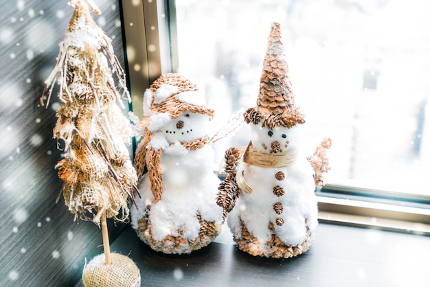 Hombres de nieve con un árbolito de navidad en miniatura