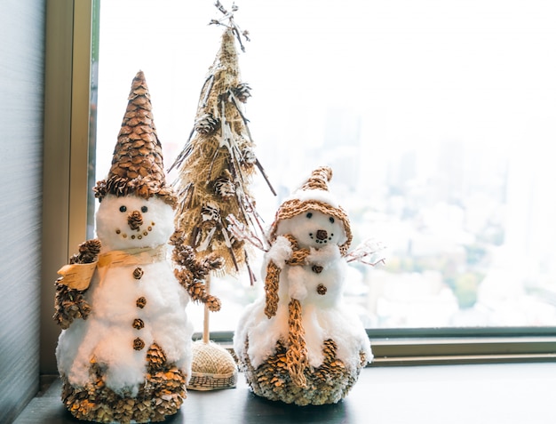 Foto gratuita hombres de nieve con un árbolito de navidad en miniatura