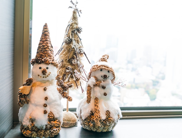 Hombres de nieve con un árbolito de navidad en miniatura