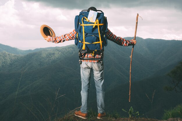 Los hombres se paran a mirar montañas en los bosques tropicales con mochilas en el bosque. Aventura, viajar, escalar.