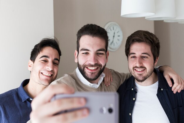 Hombres posando para selfie en oficina