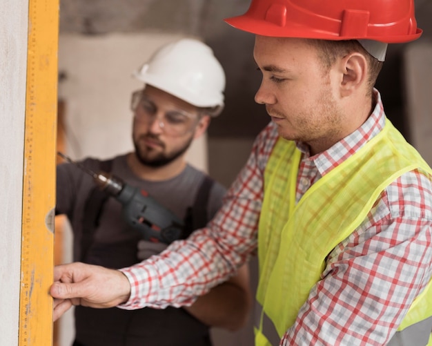 Hombres de primer plano trabajando junto con taladro