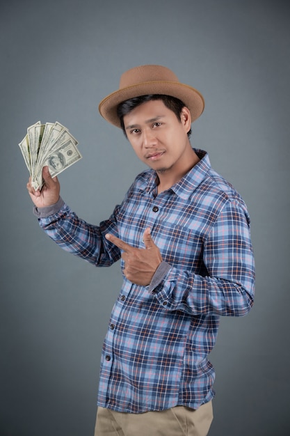 Foto gratuita hombres que sostienen un banco del dólar en un fondo gris.