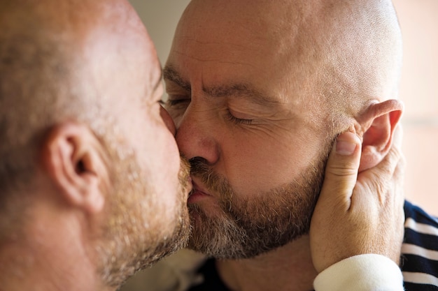 Foto gratuita hombres queer besándose vista lateral