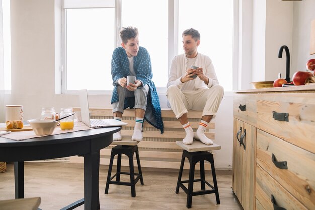 Hombres sentados cerca de la ventana sosteniendo una taza de café