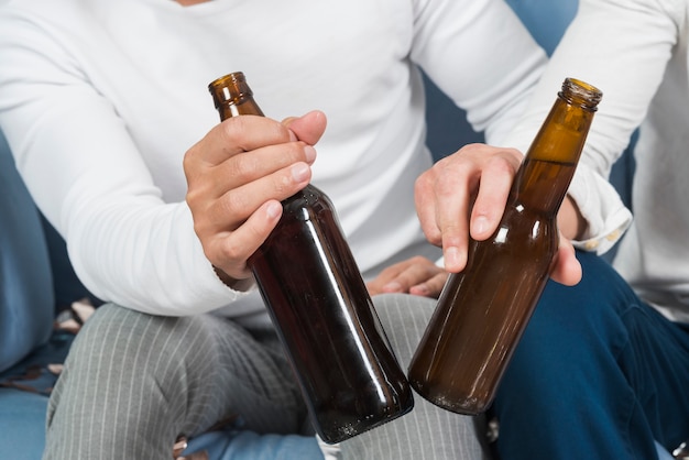 Hombres sentados con cerveza en el sofá