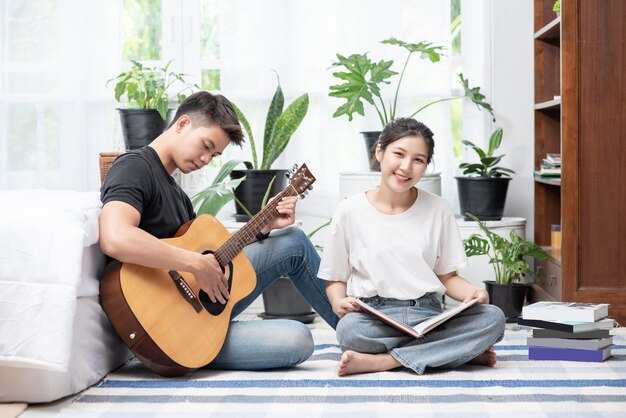 Hombres sentados guitarra y mujeres sosteniendo libros y cantando.