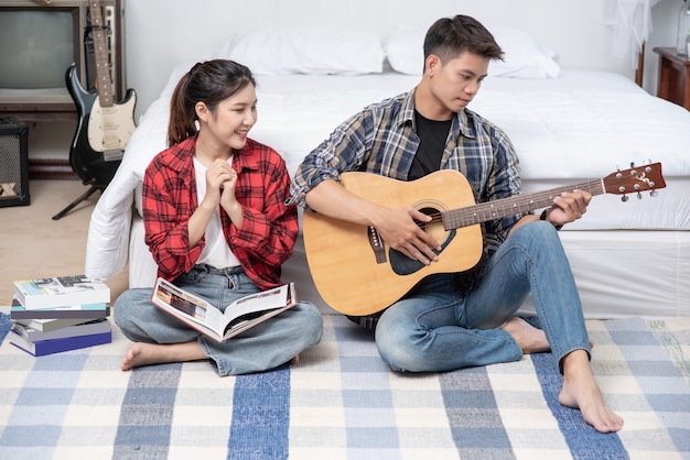 Hombres sentados guitarra y mujeres sosteniendo libros y cantando.