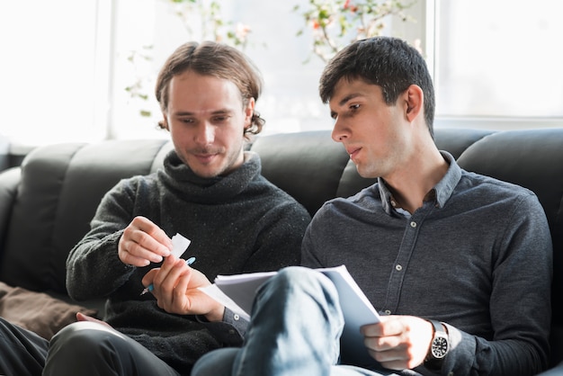 Hombres en sofá tomando notas