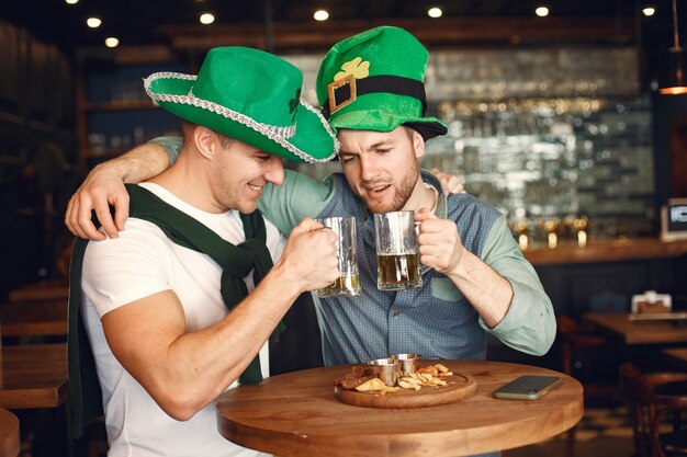 Hombres con sombreros verdes. Los amigos celebran el día de San Patricio. Celebración en un pub.