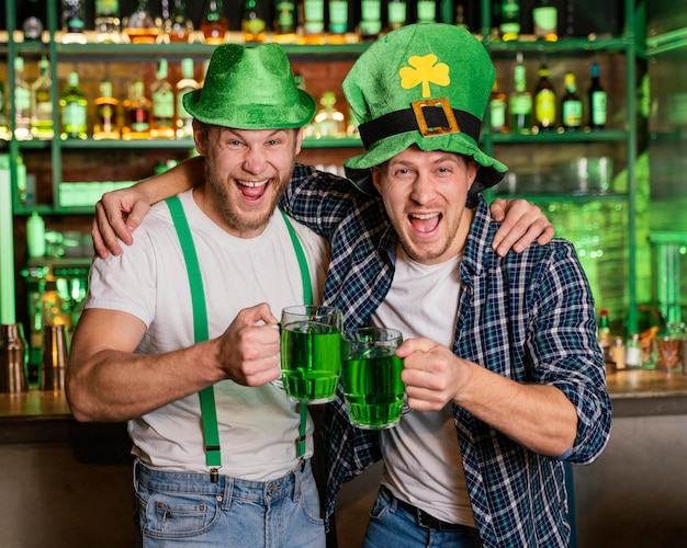 Hombres sonrientes celebrando st. día de patrick en el bar