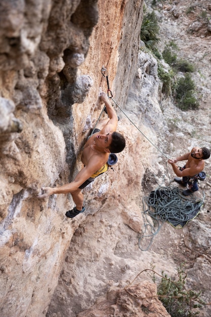 Hombres subiendo a una montaña con equipo de seguridad.