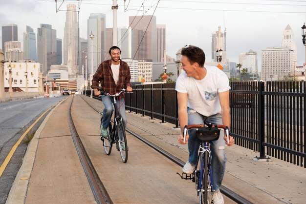 Hombres de tiro completo en bicicleta en la ciudad