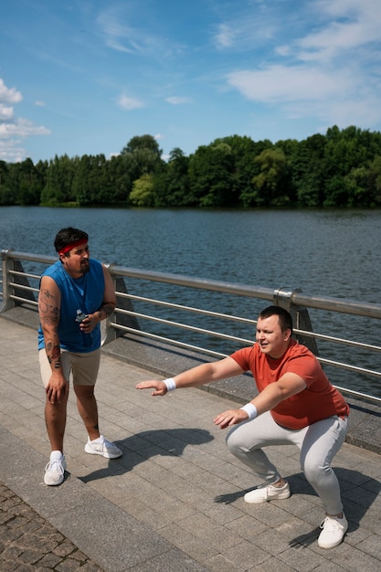 Hombres de tiro completo haciendo ejercicio juntos al aire libre