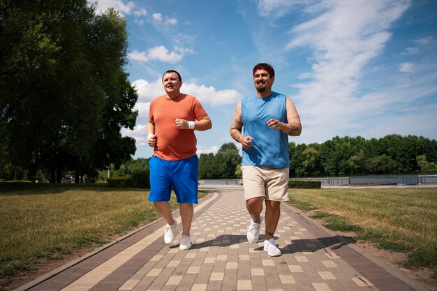 Hombres de tiro completo haciendo ejercicio juntos al aire libre