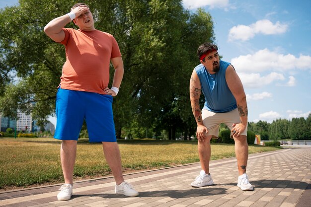 Hombres de tiro completo haciendo ejercicio juntos al aire libre