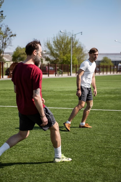 Hombres de tiro completo jugando al fútbol