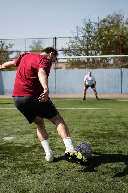 Hombres de tiro completo jugando al fútbol