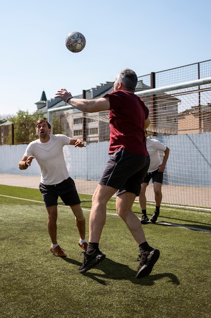 Foto gratuita hombres de tiro completo jugando al fútbol