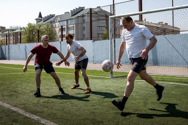 Hombres de tiro completo jugando al fútbol