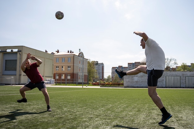 Hombres de tiro completo jugando al fútbol