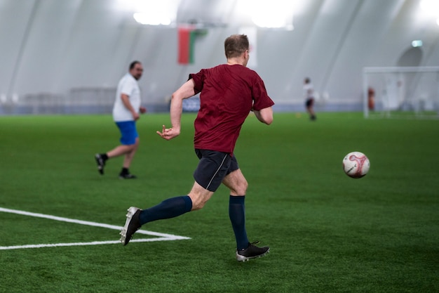 Hombres de tiro completo jugando al fútbol