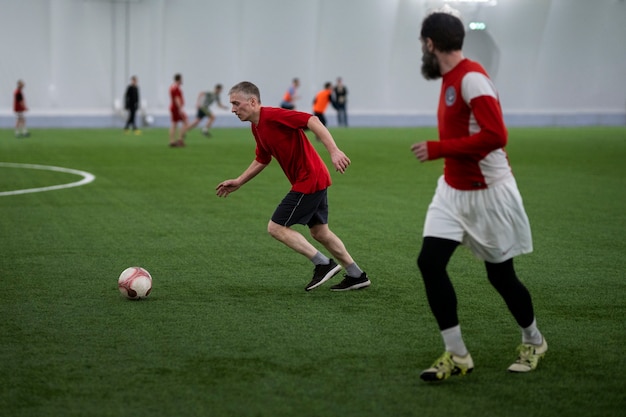 Hombres de tiro completo jugando al fútbol